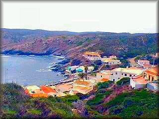 Immagine della caletta di Es Murtar, con la sua costa nera dovuta alla pietra di ardesia nera tipica di questa parte della costa di Menorca